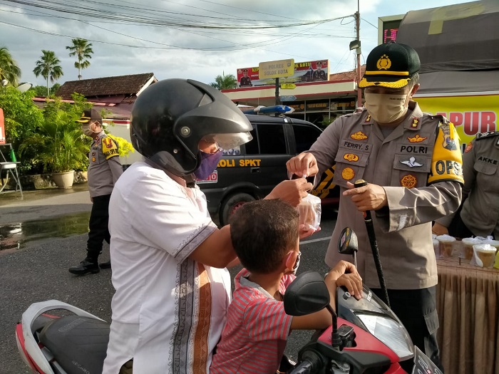 Kapolres Solok Kota sedang bagikan takjil kepada pengendara yang lewat di depan Mapolres setempat.